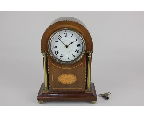 An Edwardian inlaid mahogany mantel clock, white enamel dial (with hairlines), in domed case with gilt metal pillars and ball