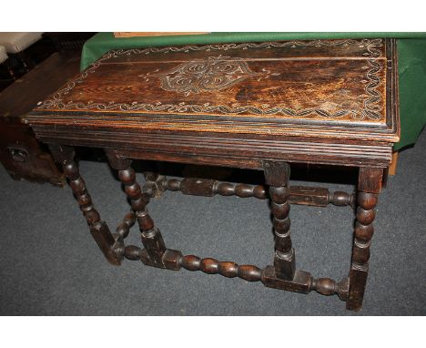 A Victorian carved oak side table, the top with central medallion and scroll surround, on bobbin turned supports and stretche