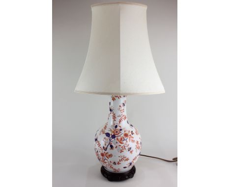A porcelain baluster table lamp with floral decoration in the Imari palette, on wooden stand, 39cm including base