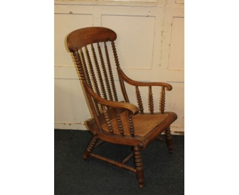 A kitchen style chair with curved rush seat and scroll arms, on bobbin turned supports