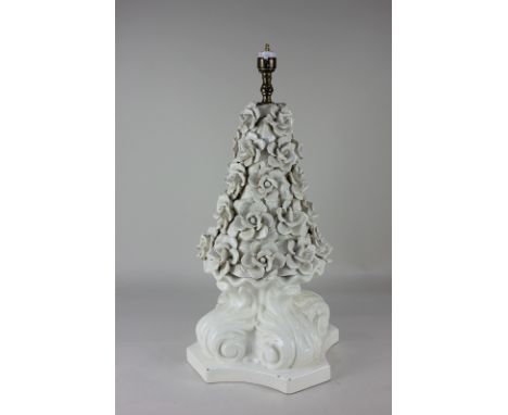 A glazed white porcelain table lamp formed as a cone of flowers, on scrolling support, 53cm