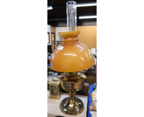 An oil lamp with amber glass shade Condition Report: Available upon request