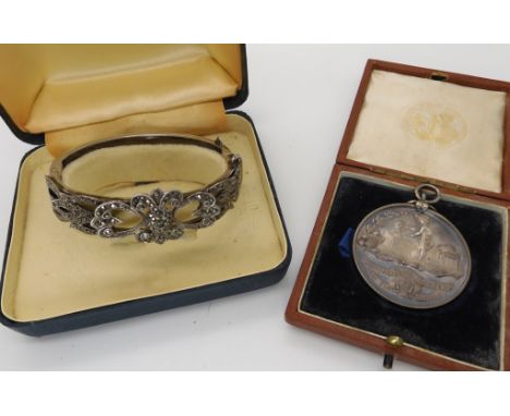 A silver marcasite bangle and a silver medallion for Cookery dated 1906 Condition Report: Not available for this lot