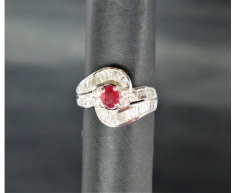 An 18ct white gold ruby and diamond ring, set with an oval faceted ruby and baguette and round brilliant cut diamonds to an 1