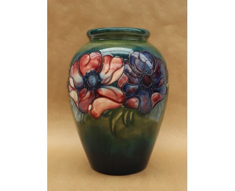 A Moorcroft pottery vase, decorated in the anemone pattern to a green ground, impressed and painted marks, paper label, 24.5c