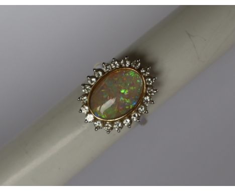 An opal and diamond dress ring, set with an oval opal approximately 14mm x 10mm surrounded by twenty round brilliant cut diam