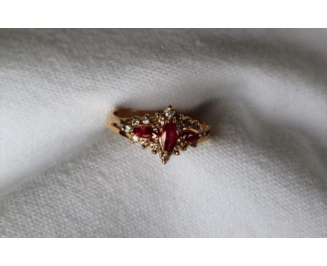 A ruby and diamond ring, set with three pointed oval faceted rubies and round brilliant cut diamonds to a 14ct yellow gold se