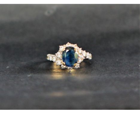 A sapphire and diamond ring, the oval faceted sapphire, approximately 9mm x 7mm surrounded by round brilliant cut diamonds to