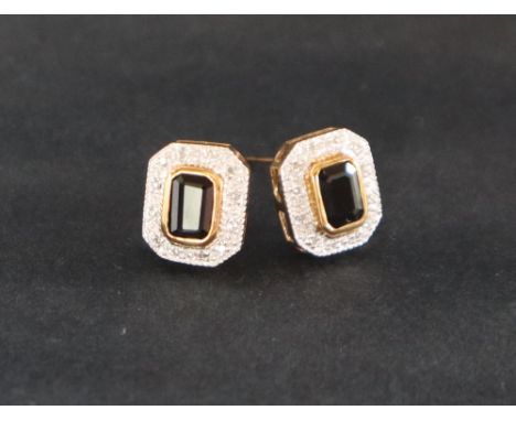 A pair of sapphire and diamond earrings, set with an emerald cut sapphire and two tiers of round brilliant cut diamonds to a 