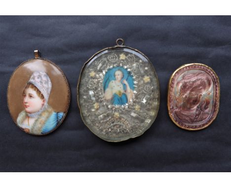 A carved mother of pearl portrait of a lady in profile in a yellow metal mount together with a head and shoulders portrait of