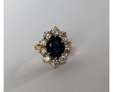A sapphire and diamond cluster ring, the central oval faceted sapphire approximately 11mm x 9mm surrounded by ten round brill