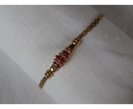 A 14ct yellow gold ruby and diamond bracelet, set with three pointed oval rubies and ten round brilliant cut diamonds, 17.5cm