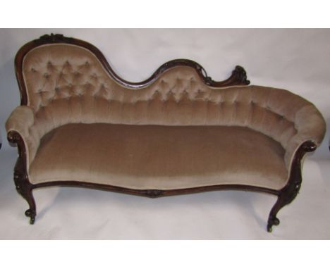 A Victorian walnut sofa, with carved show frame, having a spoon back, scroll centre and curved return, scroll and flower legs