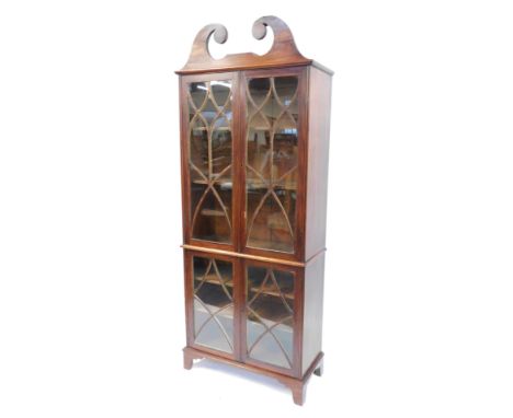 A mahogany bookcase, with an arched pediment top, above two pairs of glazed doors with shelves, on bracket feet, 206cm high, 