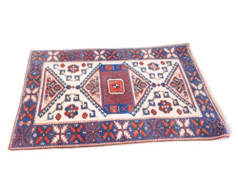 A Middle Eastern rug, on a cream, blue and red ground, with a blue border and central cream panel, with blue and red medallio