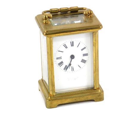 A brass carriage clock, of conventional form, with a white enamel dial beating Roman numerals, single barrel movement, with k