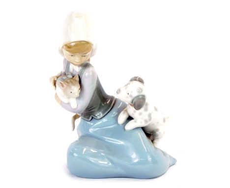 A Lladro porcelain figure of a girl, modelled kneeling with a kitten and a puppy.