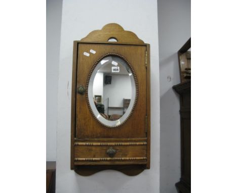 A 1920's Oak Wall Cabinet, with oval mirror and single drawer.