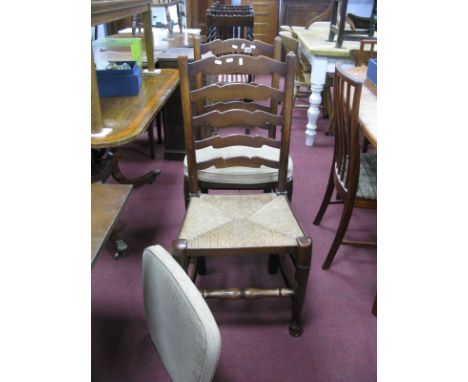 A Set of Six Oak Farmhouse Dining Chairs, with wavy ladder backs and rush seats.