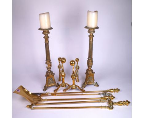 A PAIR OF EARLY 20TH CENTURY BRASS ALTAR CANDLESTICKS (6)46cm high, and a brass fire tool set including fire dogs, 26cm high