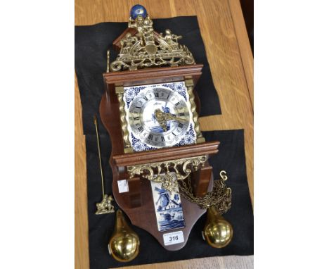 A Dutch Zaandam wall clock, pear shaped weights, Roman numerals, ceramic Blue Delft face.