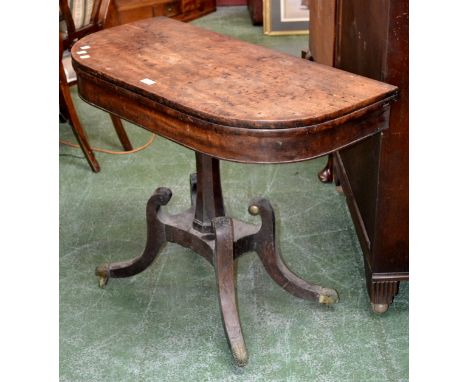 A Regency mahogany card table, fold-over top enclosing red baize playing area, incurved octagonal column, quatrefoil socle, s