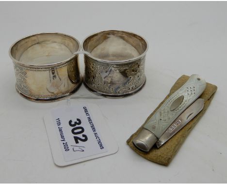 A lot comprising a pair of silver napkin rings and a silver mother of pearl fruit knife Condition Report: Available upon requ