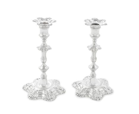 A pair of George II cast silver candlesticksJohn Cafe, London 1754 Fluted baluster knopped columns on hexafoil-shaped bases, 
