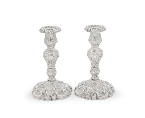 A pair of George IV silver candlesticksWaterhouse, Hodson &amp; Co, Sheffield 1828 Squat baluster form profusely embossed wit