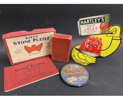 A Hartley's Jelly fridge magnet, a Lott's stone puzzel, a pack of dominoes cards and a McFarlane Lang advertising mirror.