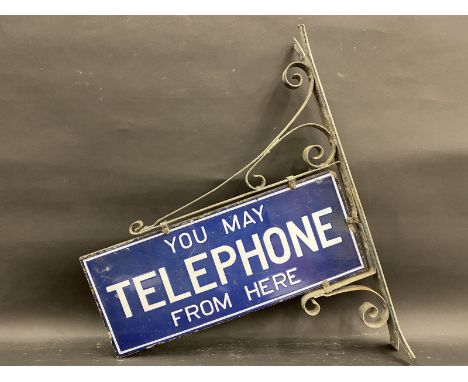 A 'You May Telephone From Here' rectangular enamel sign on original hanging bracket, 23 x 28". (including bracket).