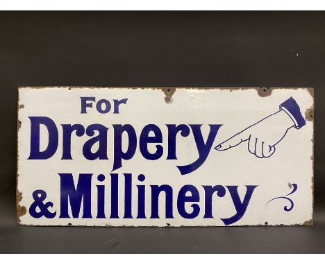 A 'For Drapery &amp; Millinery' enamel sign with pointing hand image to one corner, 36 x 17".