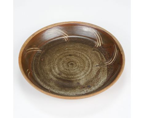 AR * Leach (David, 1911-2005). A large shallow stoneware bowl for Leach Pottery, tenmoku with wax resist combed motifs, impre