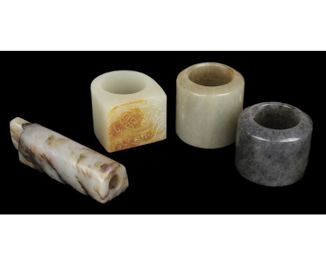 * Jade. A Chinese jade archers ring, mottled black stone, 3.5 cm diameter, together with another celadon jade archers ring, 3