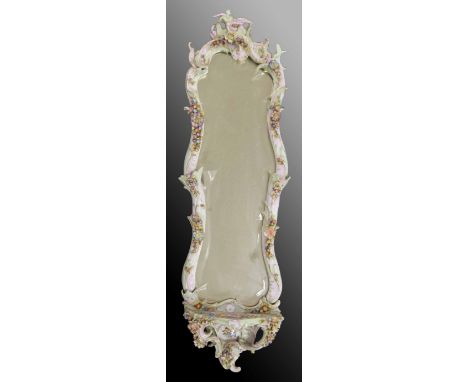 Late 19th century German porcelain framed wall mirror, the frame encrusted with flowers, the bevelled glass over a small shel