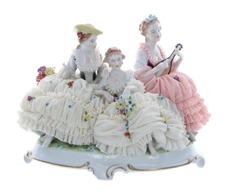 Unterweissbach porcelain figural group of three ladies in simulated net dresses encrusted with flowers, one playing a lute, b