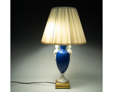 Glossy blue bulbous base with two white sculptural handles in the design of Greek women in a headdress and draped garment. To