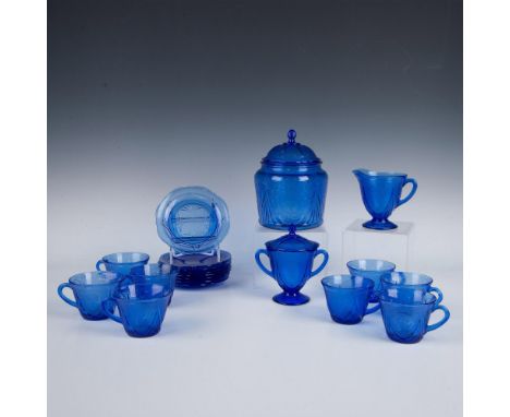 Blue depression glass decorated with lacey floral motifs. Includes a set of 8 cups and saucers, 1 footed creamer, 1 footed su