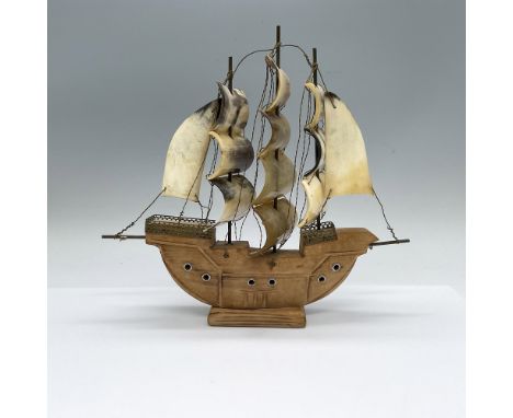 Carved wooden galleon with sails made from horn. Brass parts to accent the ship. Dimensions: 11"L x 3"W x 10"HCondition: Age 