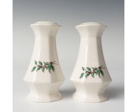 A set of 2 white table shakers decorated with illustrations of a holly branch. JAPAN stamped in green on the bottoms. This it