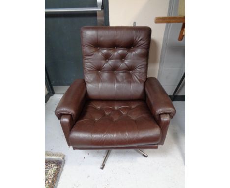 A 20th century brown button leather swivel armchair on chrome base.  