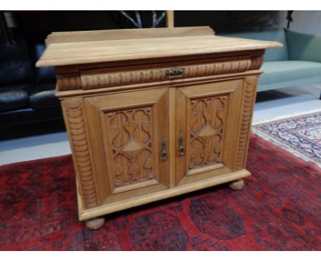 A 20th century continental oak double door low sideboard with carved panel doors, fitted drawer above.   