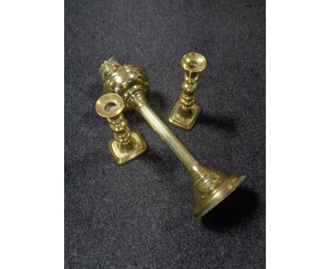 An antique brass Corinthian column oil lamp base and a pair of antique brass candlesticks 