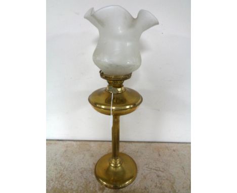 A brass oil lamp with glass shade