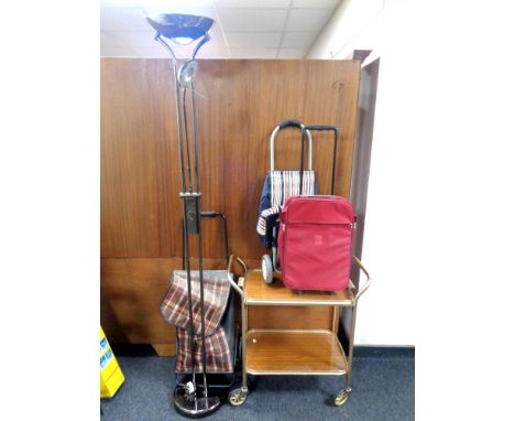 A contemporary floor lamp together with a 20th century two tier trolley, a luggage case and two shopping trolleys, a black fr