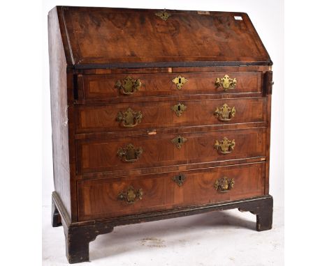An 18th century George III Queen Anne walnut and brass bureau desk. The bureau having a fall front top section opening to rev