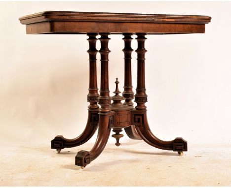 A 19th century William IV walnut card - games table. Raised on a splayed leg quatrefoil base with four rising columns to a re