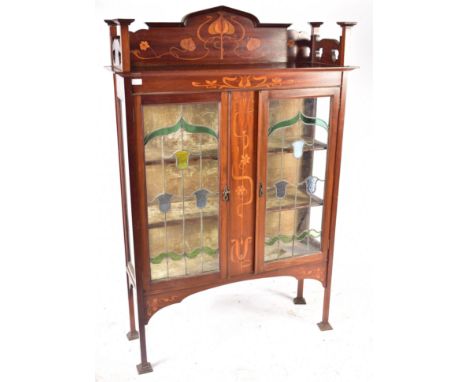 An Edwardian mahogany inlaid Arts &amp; Crafts display cabinet in the Glasgow school manner. The cabinet having a raised carv