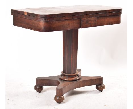 A 19th century WIlliam IV rosewood games - card table. Raised on a quatrefoil base with bun feet having shaped column to fold