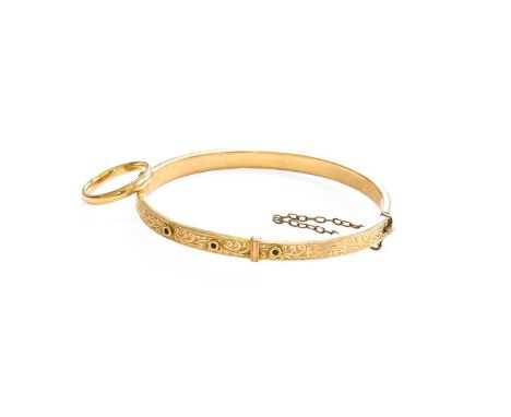 A 9 Carat Gold Hinged Bangle, inner measurements 6.0cm by 4.8cm; and A 9 Carat Gold Band Ring, finger size I1/2Gross weight 9
